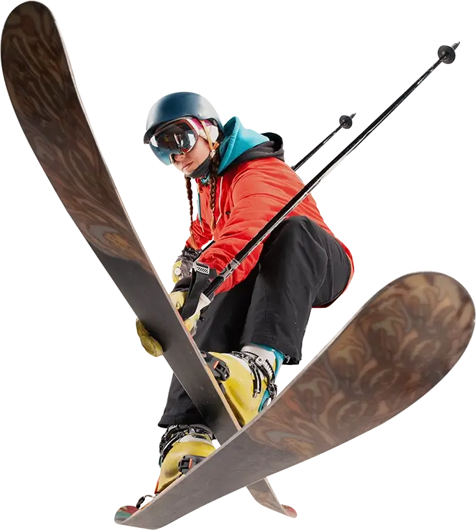 Female skier in an orange jacket crossing their skis and pointing their poles backwards.